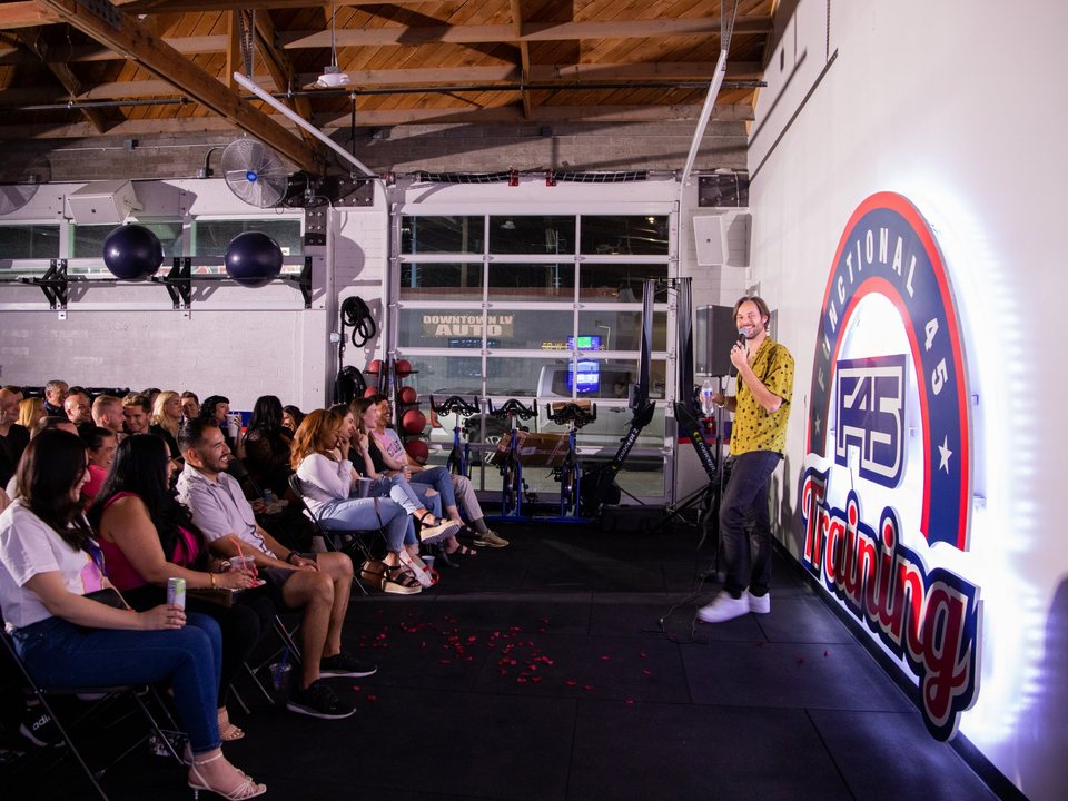 A comedian performs for a packed crowd inside the F45 gym in the Las Vegas Arts District